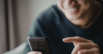 スマートフォンを使って笑顔の男性